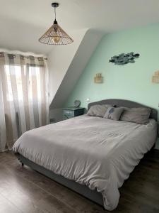 a bedroom with a large bed in a room at Du gite dans les Toiles in Wimereux