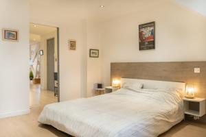a bedroom with a large white bed with two lamps at Le Victor Hugo Appartement T3 proche Musée Soulages in Rodez