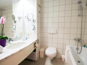 a white toilet sitting next to a sink in a bathroom at Arion Cityhotel Vienna und Appartements in Vienna