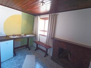 sala de estar con chimenea y TV en Pousada Da Santina en Visconde De Maua