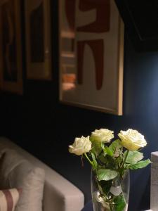 un jarrón lleno de rosas blancas sentadas en una mesa en Apartament Zamkowy 2 en Kwidzyn
