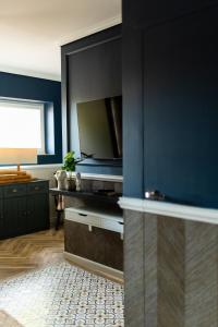 uma sala de estar com televisão e uma parede azul em Apartament Zamkowy 2 em Kwidzyn