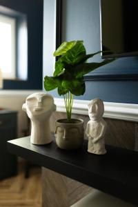 a shelf with a plant and two statues on it at Apartament Zamkowy 2 in Kwidzyn
