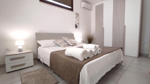 ein Schlafzimmer mit einem Bett mit Handtüchern darauf in der Unterkunft Residenza Arcangela con Piscine nel Salento in Corsano