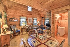 a dining room and living room in a log cabin at Peaceful Mountain City Cabin with Porch and Fire Pit in Mountain City