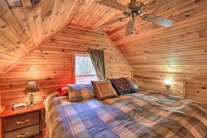 a bedroom with a bed in a log cabin at Peaceful Mountain City Cabin with Porch and Fire Pit in Mountain City