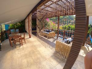 a patio with a table and chairs and a pergola at Pousada Villa Atlântica in Camburi