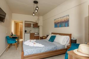 a small bedroom with a bed and a kitchen at Asterion Luxury Studios Airport in Heraklio Town