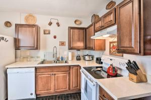 a kitchen with white appliances and wooden cabinets at Cozy Galveston Apartment - Walk to Beach and Dining in Galveston +19 photos