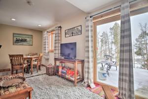 a living room with a table and a television and a window at Cozy Mountain Getaway with Ski Shuttle Access! in Fraser