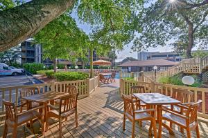 een houten terras met tafels en stoelen in een straat bij Condo with 2 Balconies - Across From Myrtle Beach! in Myrtle Beach
