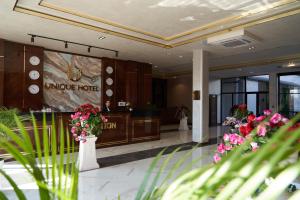eine Lobby eines Hotels mit Blumen auf dem Boden in der Unterkunft UNIQUE HOTEL in Chilanzar
