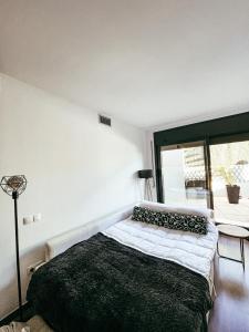 a bedroom with a bed and a large window at Sunset Deluxe con jacuzzi, piscina y barbacoa in Calafell +12 photos