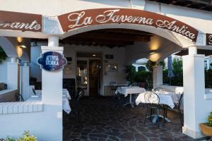 a restaurant with tables and chairs and a sign at La Taverna Antica Rooms in Pescara