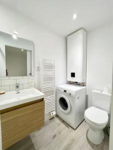 a bathroom with a washing machine and a toilet at T2 refait à neuf Hyper Cosy - À 50m des plages in Larmor-Plage