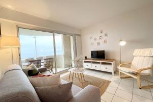 a living room with a couch and a television at SPLENDIDE ! T2 Archi Cocooning Vue mer 180 in Ploemeur