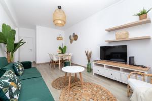 ein Wohnzimmer mit einem Sofa und einem TV in der Unterkunft Akisol Albufeira Light in Albufeira