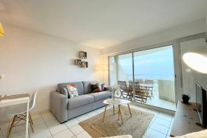 a living room with a couch and a view of the ocean at SPLENDIDE ! T2 Archi Cocooning Vue mer 180 in Ploemeur