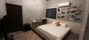 a bedroom with a white bed and pictures on the wall at 澎湖海景民宿 島嶼時光 Island Time Homestay in Magong