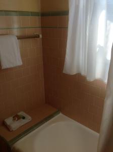 a bathroom with a tub and a shower with a white curtain at Historic Dow Hotel in Lone Pine