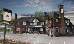 a large brick building in a parking lot at The Chequers Inn in Knebworth