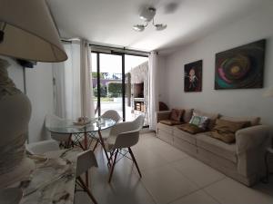 ein Wohnzimmer mit einem Sofa und einem Tisch in der Unterkunft Apartamento Edificio Unique, Punta del Este in Punta del Este