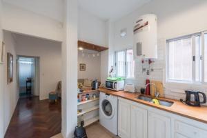 a kitchen with a sink and a washing machine at One bedroom in La Boca, Popular & Artistic District in Buenos Aires