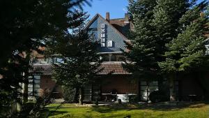 a large brick building with trees in front of it at Hotel Restaurant Landluft in Aerzen