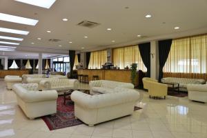 eine Lobby mit weißen Sofas, Tischen und Stühlen in der Unterkunft Park Hotel Paradiso in Piazza Armerina