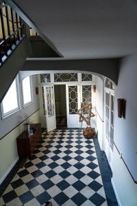 einen Flur mit einem karierten Boden und einer Treppe in der Unterkunft Ferienwohnung Klosterstraße direkt am Schloß in Schwerin