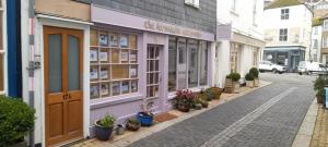 a street with a shop with flowers in pots at Foss Room in Dartmouth