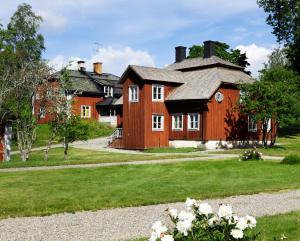 Casa de madera grande con ventanas blancas y patio en Handlarens villa - Vandrarhem de luxe en Söderbärke