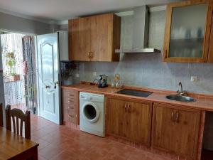 uma cozinha com um lavatório e uma máquina de lavar roupa em Andalusian farmhouse with barbecue, pool and wifi em Málaga