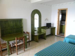 a room with a desk and a bed and a mirror at Residence Letojanni Taormina in Letojanni