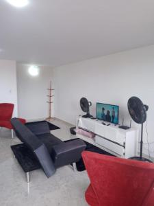 un soggiorno con divano e sedie rosse di Apartamento Duplex Mobiliado em São Pedro da Aldeia a São Pedro da Aldeia