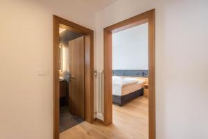 a bedroom with a bed and a door with a window at La Grambla App Mont Seuc 1 in Santa Cristina in Val Gardena