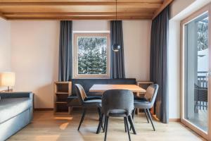 a dining room with a table and chairs and a window at La Grambla App Mont Seuc 1 in Santa Cristina Gherdëina