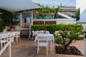een restaurant met witte tafels en stoelen op een patio bij La Taverna Antica Rooms in Pescara