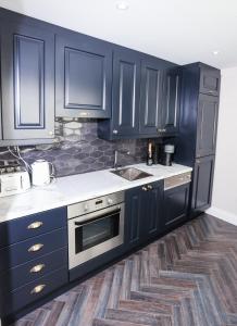 a kitchen with navy blue cabinets and a sink at Luxury 2 bed 5 mins from Carrick next to Waterfall in Carrick on Shannon