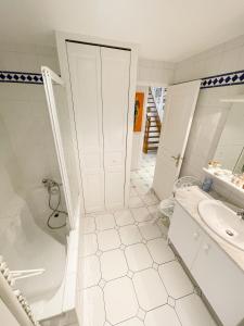 a white bathroom with a tub and a sink at Le Pommeraye : Duplex hyper centre in Nantes