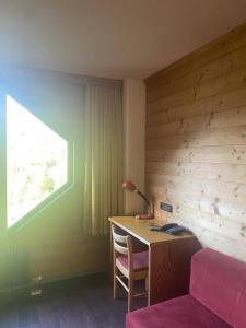 a bedroom with a desk with a lamp and a window at Residence kurtz in Maso Corto