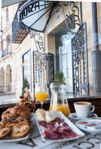 una mesa con un plato de comida y un vaso de zumo de naranja en Hotel Soria Plaza Mayor, en Soria