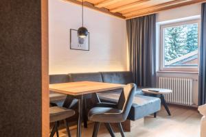 a dining room with a table and chairs and a window at La Grambla App Saslonch in Santa Cristina Gherdëina