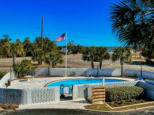 uma piscina com uma bandeira americana num parque em Waterway View Studio 2 w/ Pool, 1 mile to Wrightsville Beach em Wilmington
