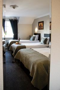 fila de camas en una habitación de hotel en The Harbour Inn, en Buncrana