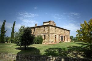 ein altes Steinhaus auf einem Grasfeld in der Unterkunft Agriturismo tranquillo e con vista panoramica in Torrita di Siena