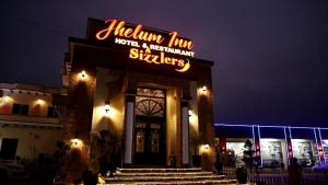 a restaurant with a neon sign in front of it at Jhelum Inn Hotel in Jhelum