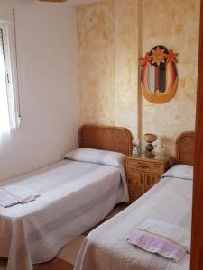 a bedroom with two beds and a mirror on the wall at Las Cuatro Lunas in Níjar