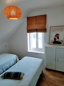 1 dormitorio con 2 camas y ventana en Maison rénovée avec jardin proche grande plage en Quiberon