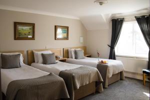 a hotel room with two beds and a window at The Harbour Inn in Buncrana